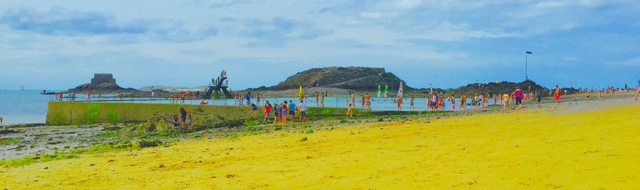 People at beach against sky