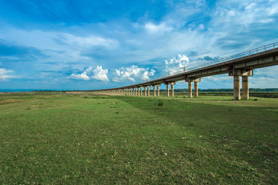 Bridge over field against sky