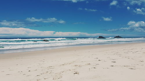 View of calm beach against blue sky