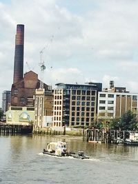 Boats in river with buildings in background