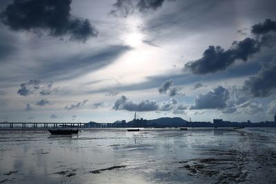 Scenic view of boats in sea against cloudy sky