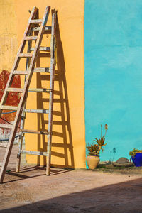 Ladder against yellow and blue wall 