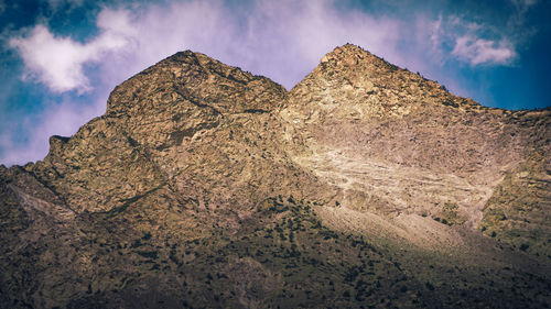 Low angle view of rocky mountain against sky