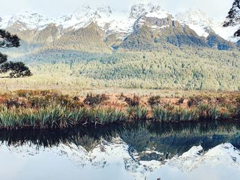 Scenic view of lake by mountains during winter