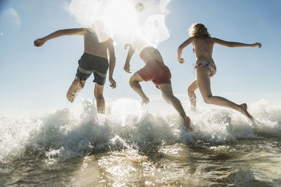 Friends jumping into the sea