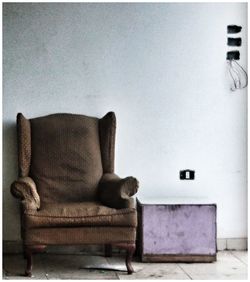 View of an animal sitting on chair against wall