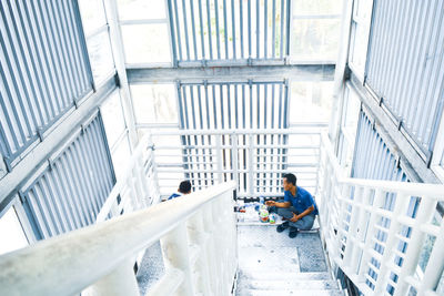 High angle view of man sitting by steps