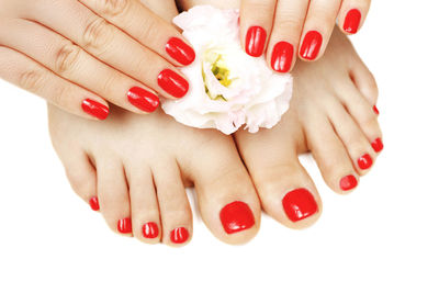 Close-up of woman hand with red hands over white background