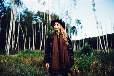 Portrait of a young woman standing on field