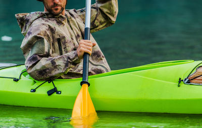 Midsection of man kayaking in lake