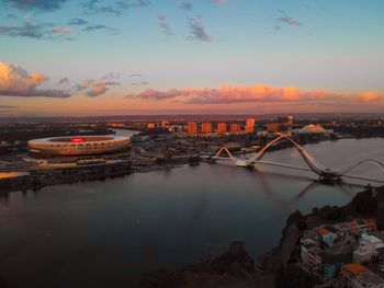 Aerial view of bridge over river against sky during sunset