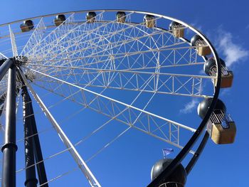 Low angle view of ferris wheel against blue sky