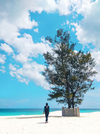 Full length of woman on beach against sky