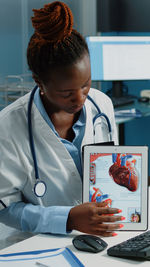 Doctor showing digital tablet at hospital