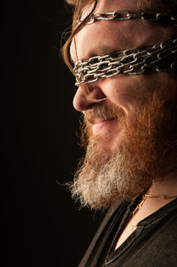 Close-up portrait of man against black background