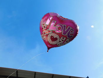 Low angle view of heart shape against blue sky