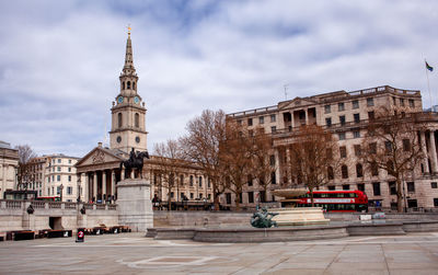 Buildings in city against cloudy sky