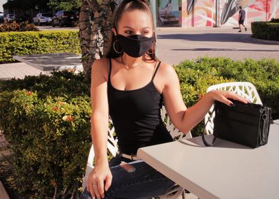 Portrait of young woman wearing a mask outdoors