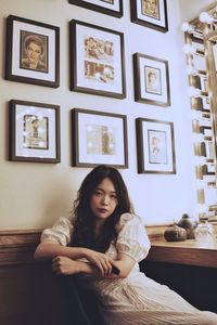 Portrait of woman sitting on wall at home