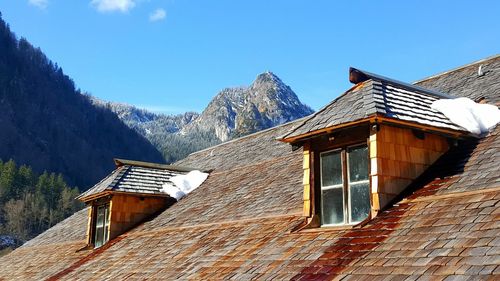Low angle view of houses against clear blue sky