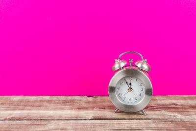 Close-up of clock on table against wall