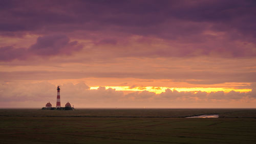 Scenic view of agricultural landscape against sky during sunset