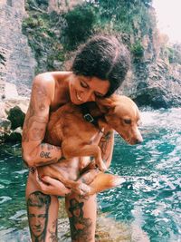 Portrait of woman with dog in water