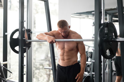 Full length of shirtless man looking at camera