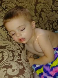 Close-up of cute baby girl on bed