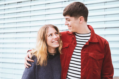 Happy young couple looking at each other while standing outdoors