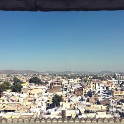 High angle view of houses against clear blue sky
