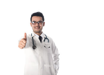 Portrait of doctor showing thumbs up over white background