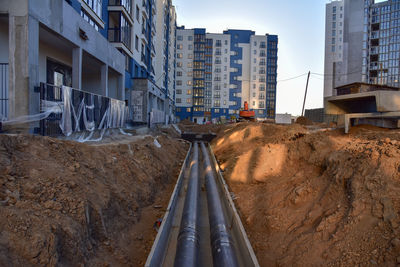 Laying heating pipes in a trench at construction site. install underground storm systems
