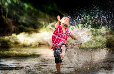 Boy splashing water in lake
