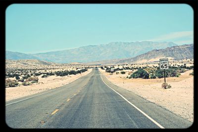 Empty road leading towards mountains