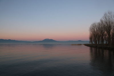 Scenic view of lake against clear sky during sunset