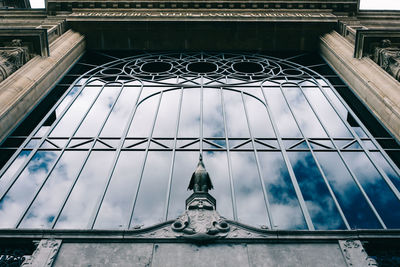 Cloudy sky reflecting on window of building