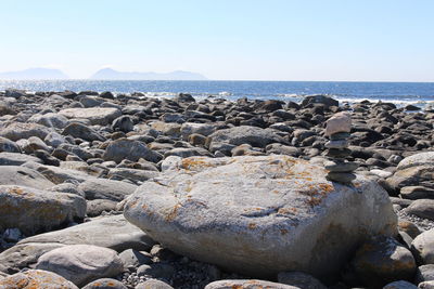 Rocks on beach against clear sky