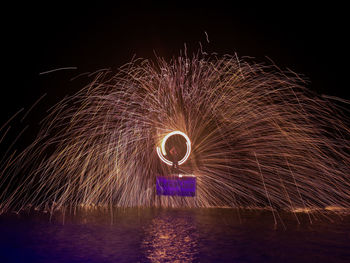 Man spinning wire wool at night