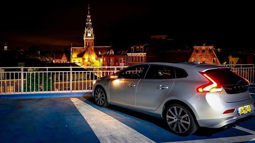 Car on illuminated city against sky at night