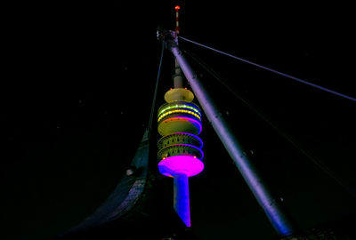 Low angle view of illuminated lighting equipment hanging at night