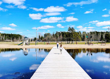 Siblings at the lake beach dock 