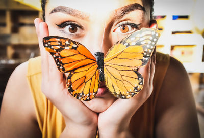 Close-up portrait of a person holding butterfly