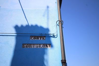 Close-up of information sign against clear blue sky