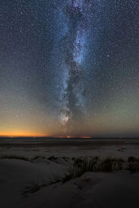 Bright vertical milky way over the north sea on amrum island germany with sunset glow