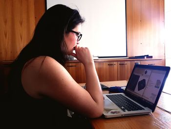 Young woman using mobile phone at home