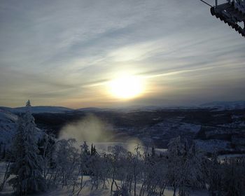 Snow covered landscape at sunset