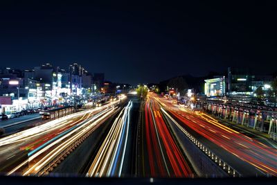 Light trails on road against sky at night