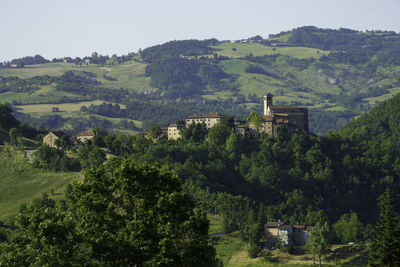 Scenic view of trees and buildings against sky