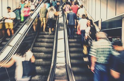 Blur image of crowd traveling on escalators
